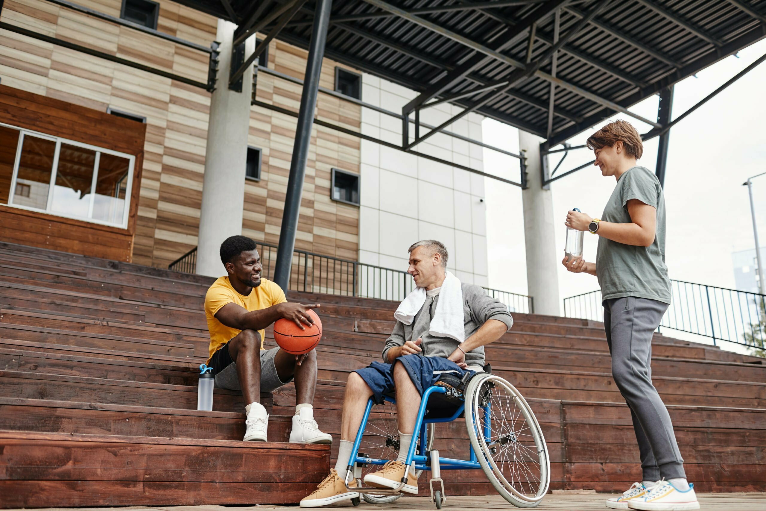 Paraplegic man and athlete discussing sports after a game, promoting inclusive perspectives.