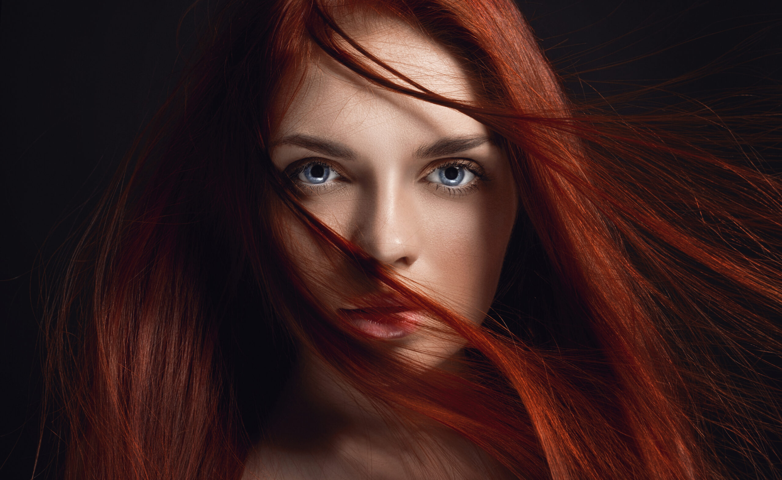Beautiful redhead with long, flowing hair showcasing healthy, vibrant tresses