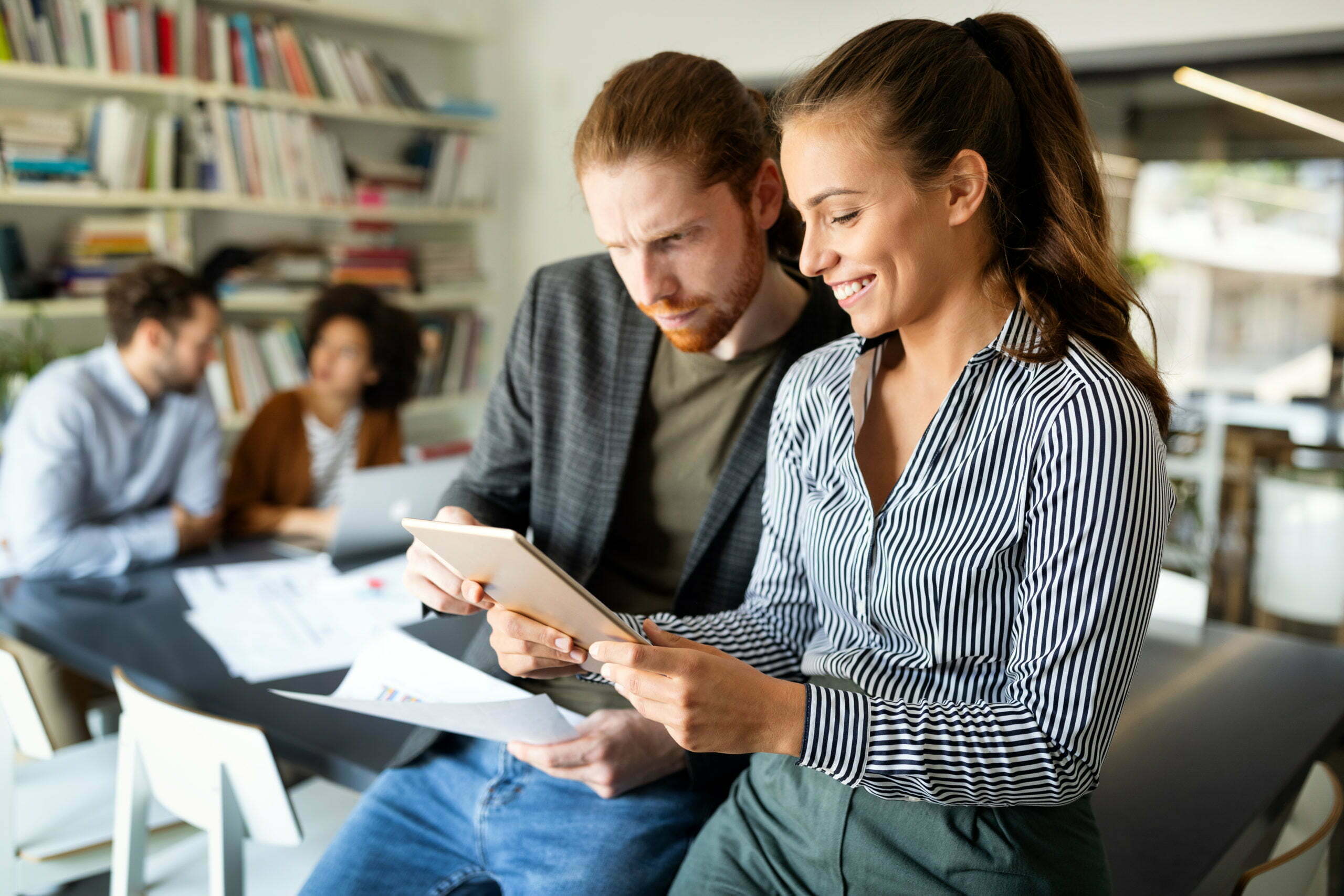 a woman and a man looking at a paper