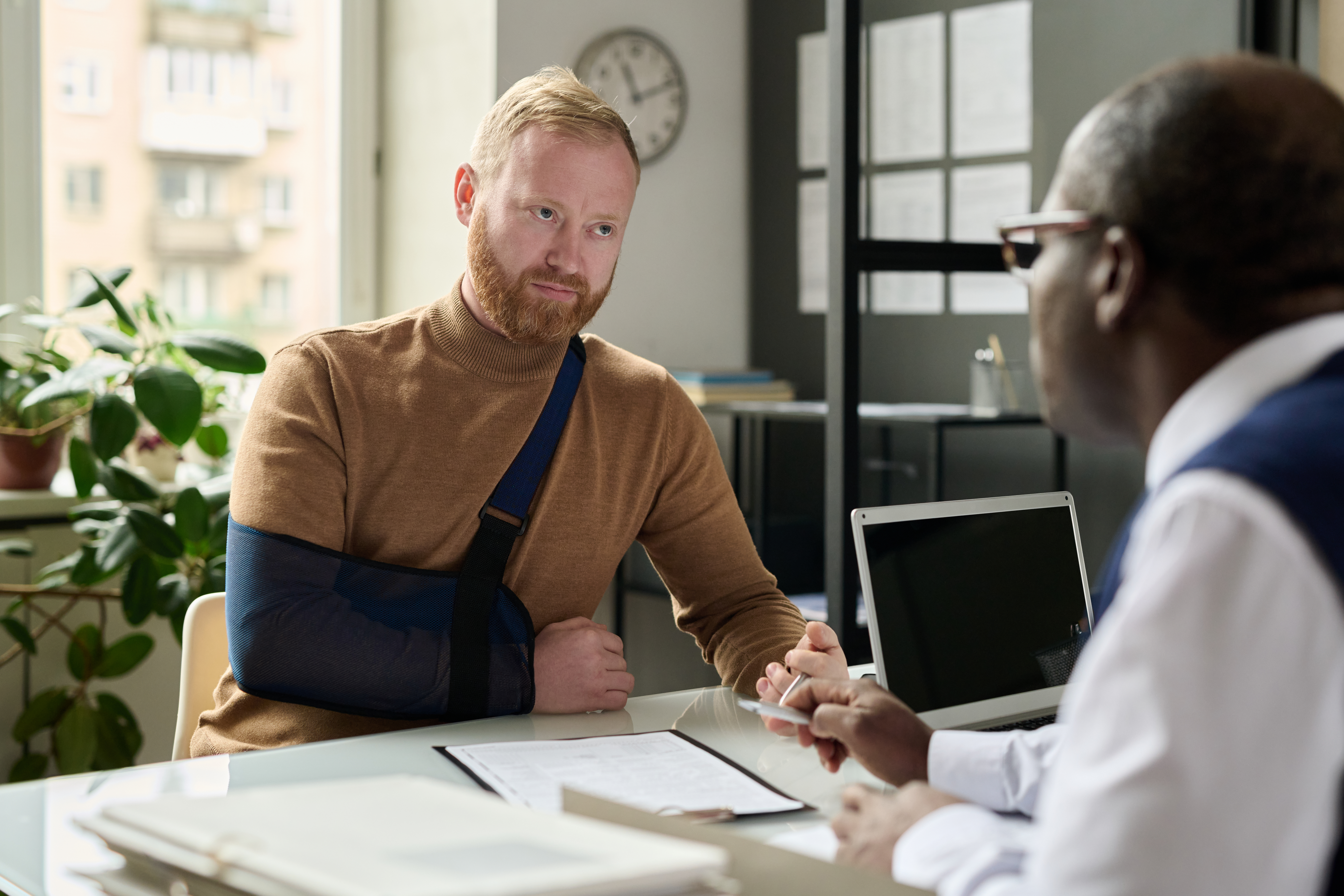 Man consulting with insurance broker after accident and injury