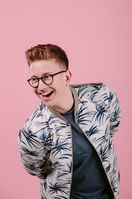 Reid Rowan, Q Entertainment author, smiling and wearing a tropical print jacket.